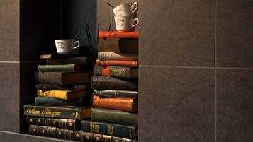 A stack of books with a coffee cup on top.