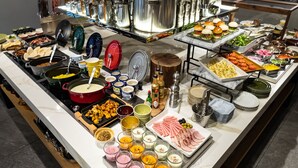 A buffet with various food items and condiments.