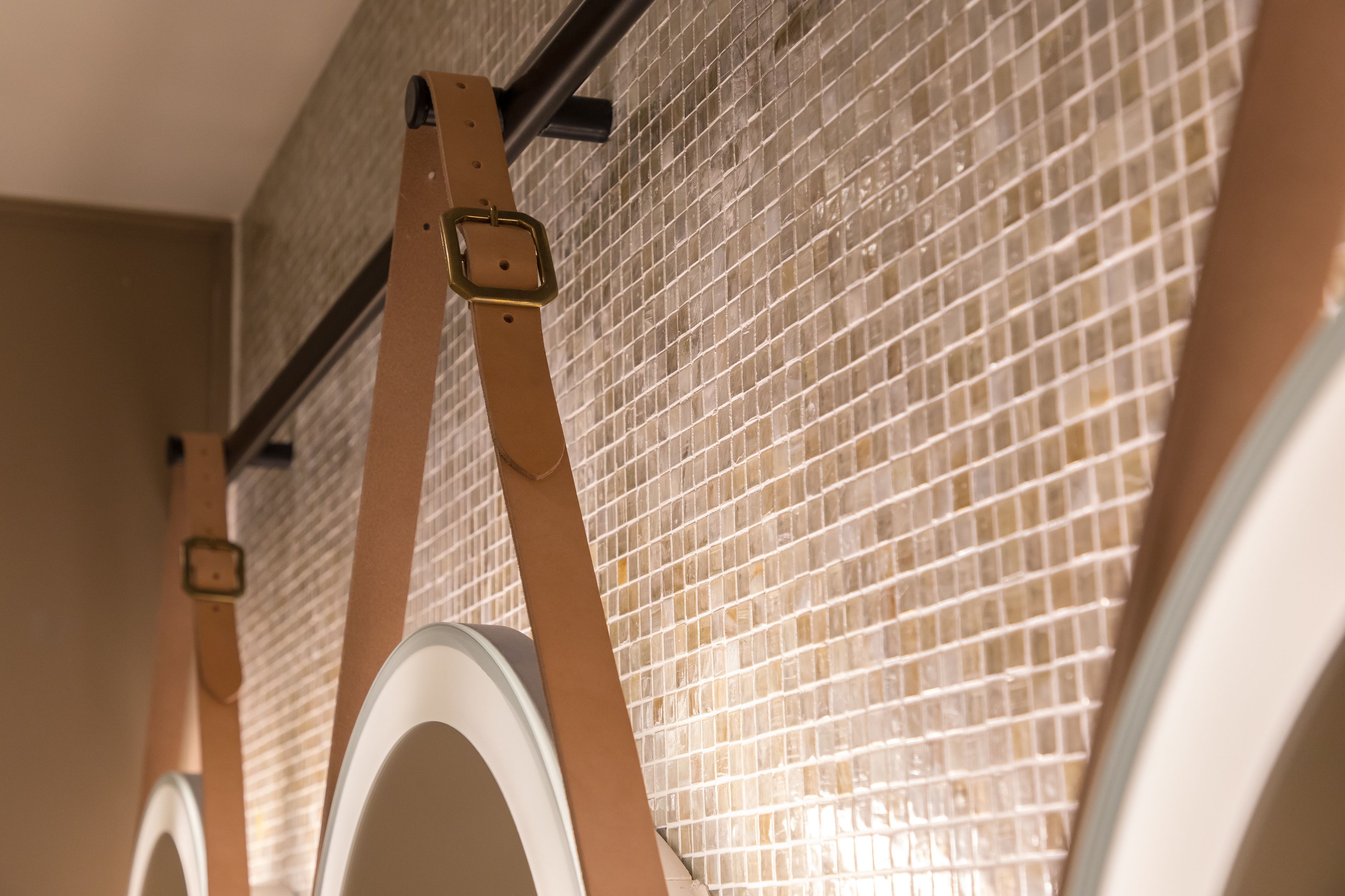 A close-up of a bathroom with a tiled wall and a towel rack.