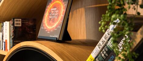 A bookshelf with books and a book titled "The Origin of (Almost) Everything" by a New Scientist author.