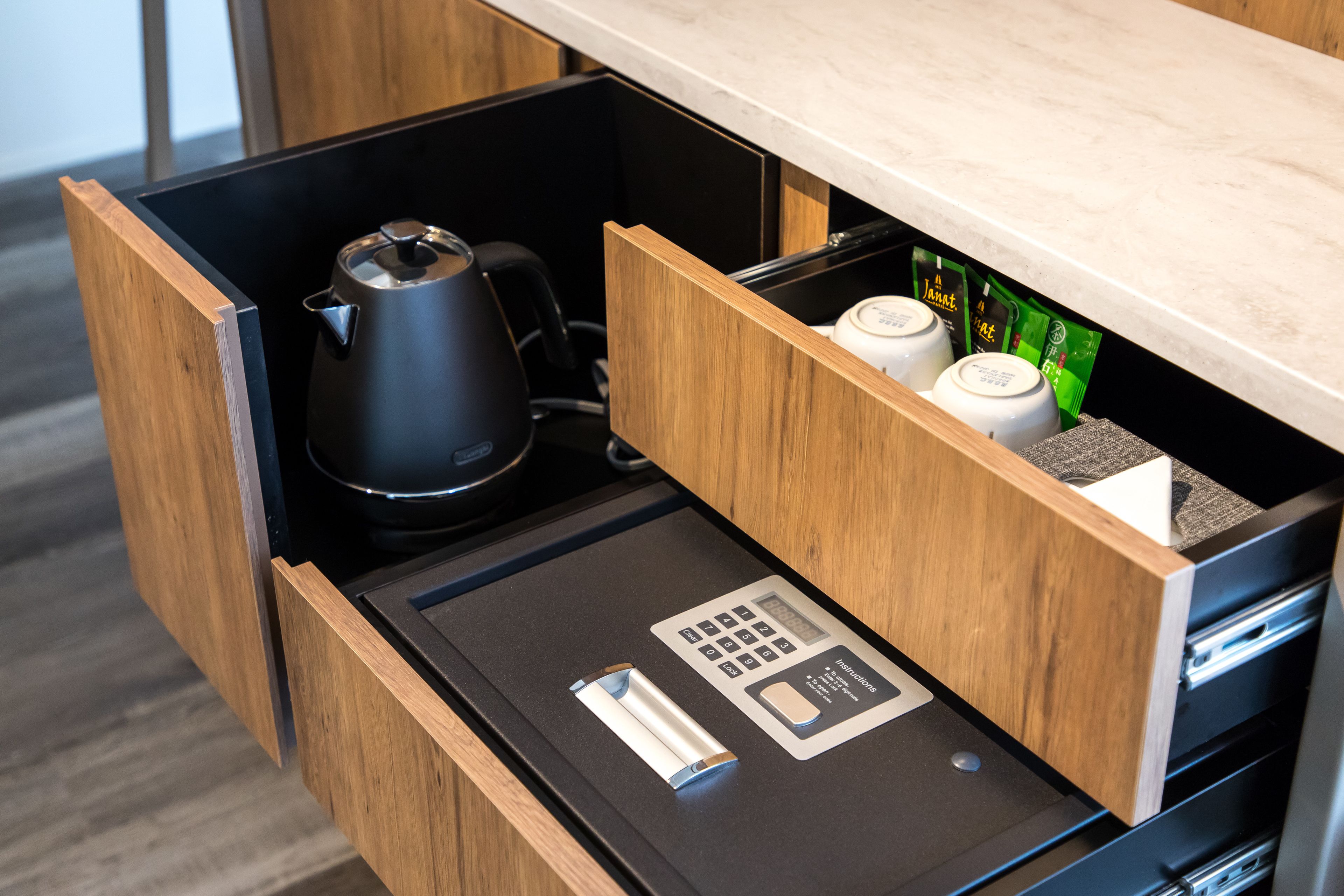 A drawer with a coffee maker, a kettle, and a small appliance with a control panel.