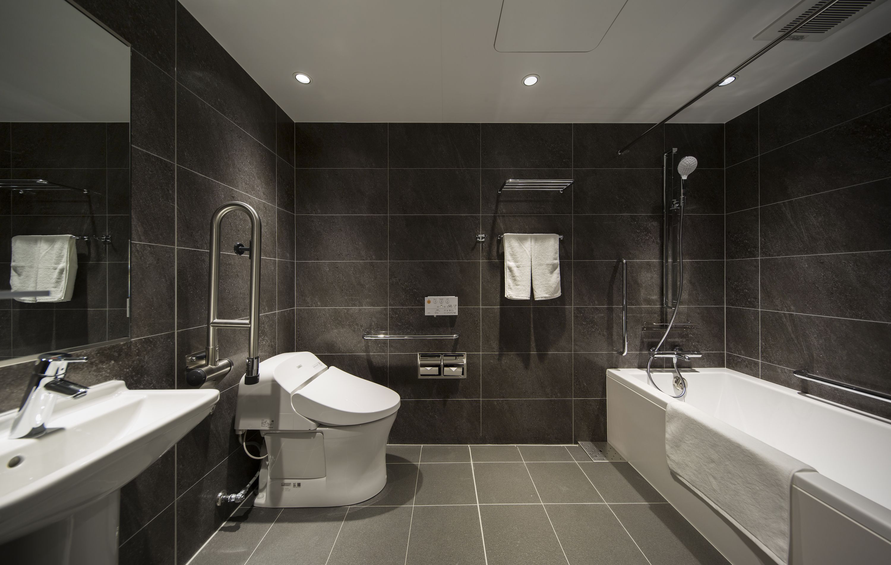 A modern bathroom with a toilet, sink, and bathtub.