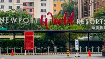 The exterior of Newport World Resorts with a signboard displaying amenities and directions.