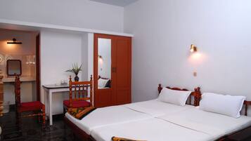 A hotel room with a bed, a desk, a chair, and a wardrobe.