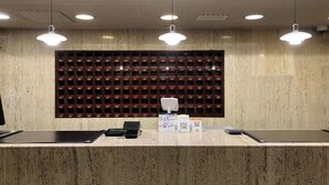 A reception desk with a marble counter, a wall-mounted mailbox, and overhead lighting.