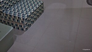 Una habitación con armario, cama con cubrecama estampado y equipo de aire acondicionado en la pared.