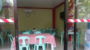 Un comedor con mantel a cuadros, sillas turquesa y un reloj en la pared.