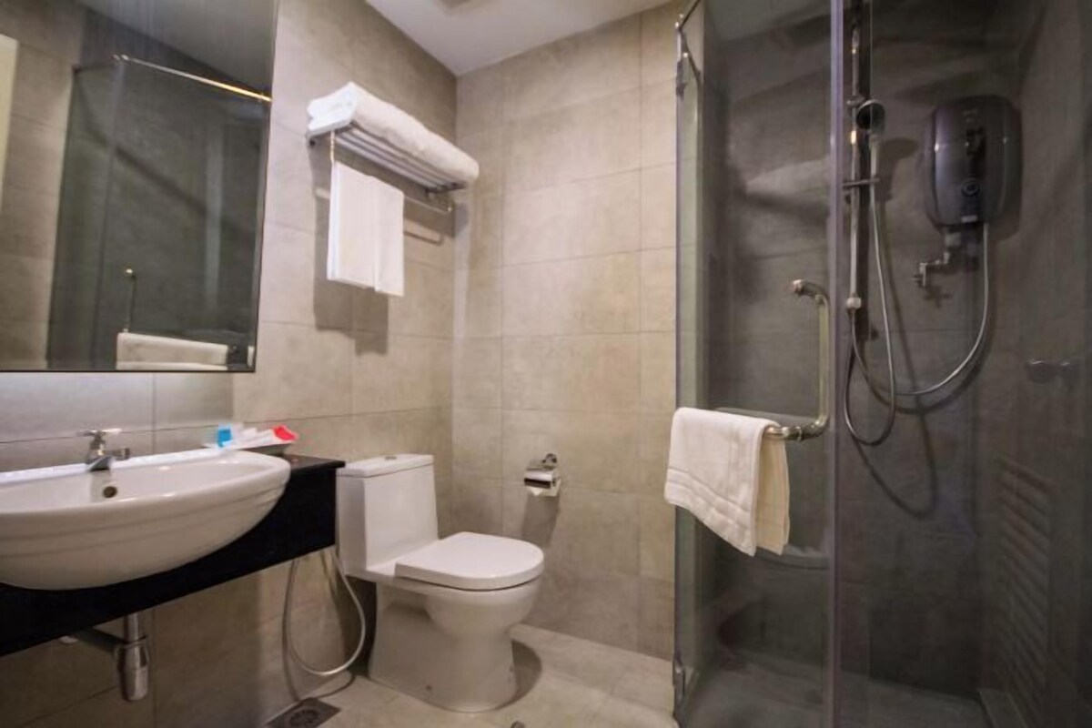 A bathroom with a sink, toilet, and glass-enclosed shower.