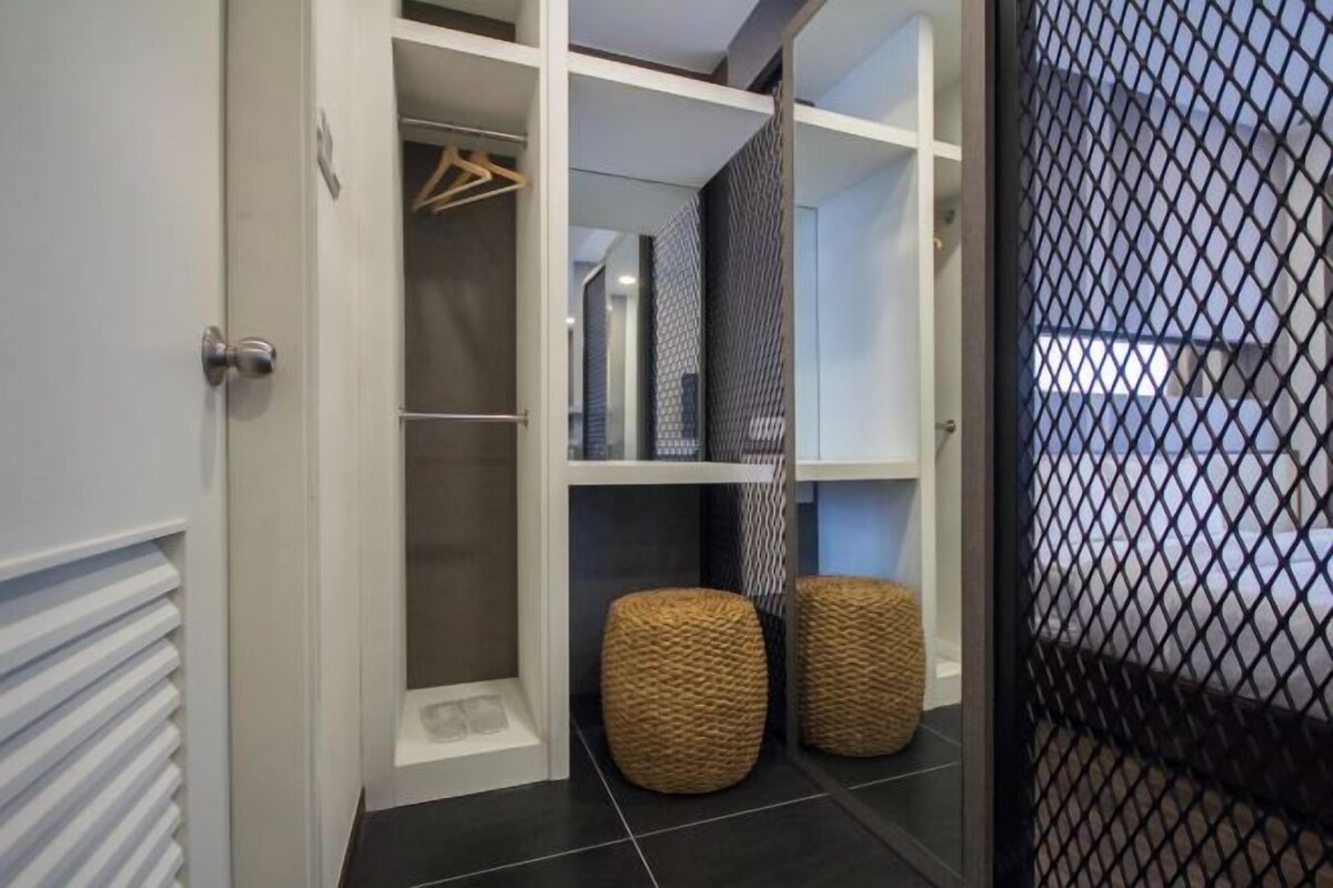 Un placard moderne avec des portes ouvertes, des étagères et un espace pour suspendre les vêtements.