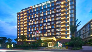 A multi-story hotel with a prominent entrance and a flag. - Days Hotel by Wyndham Haikou Meilan Airport (Haikou)