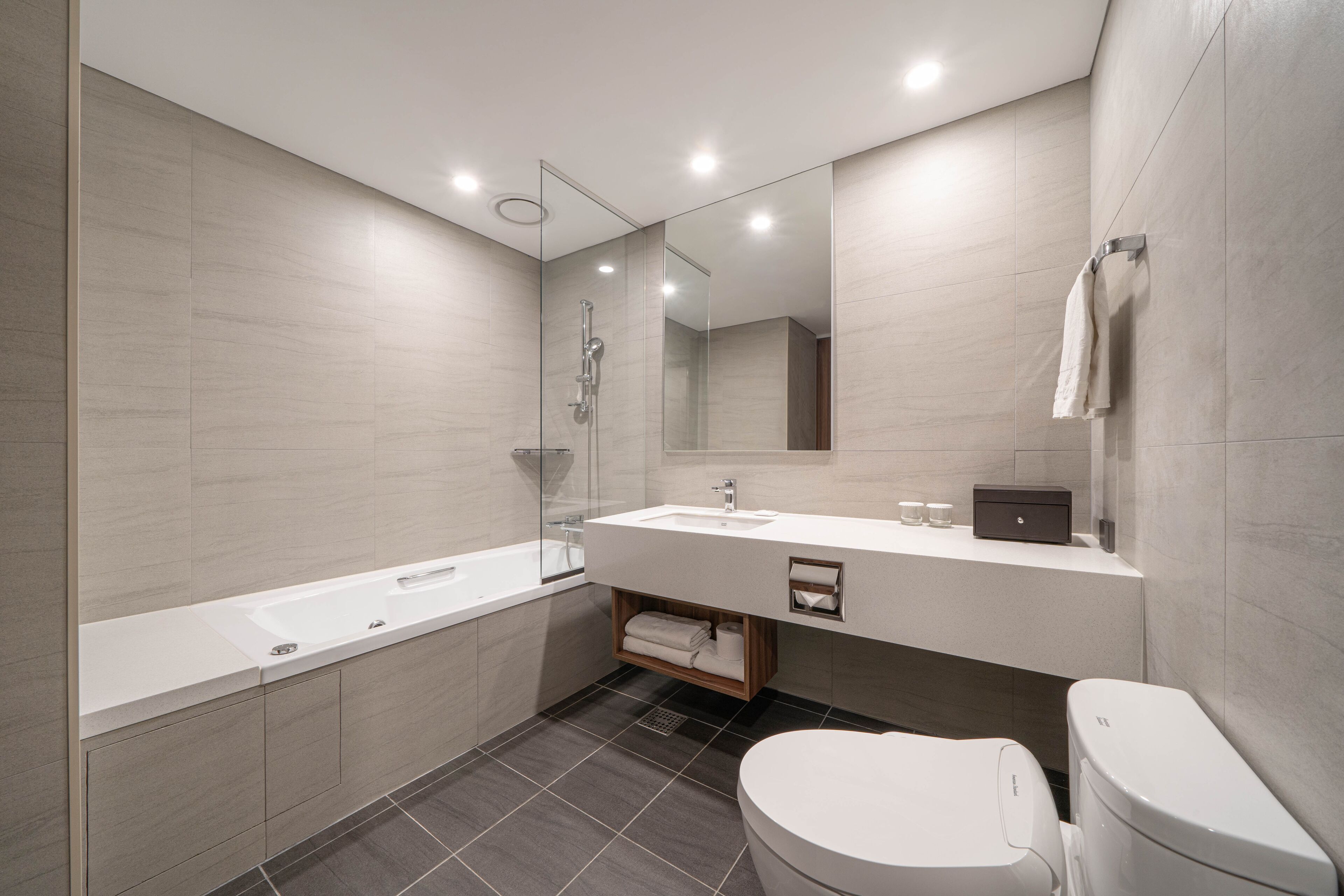 A modern bathroom with a large bathtub, a sink, and a toilet.