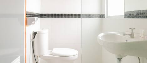 A bathroom with a toilet, sink, and a tiled backsplash.