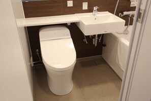 A compact bathroom with a white toilet, a sink, and a bathtub. - Hotel Biwako Cerisaie (Otsu)