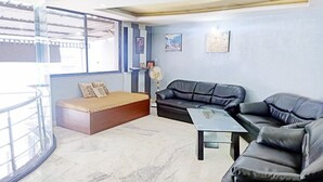 Una sala de estar con sofá, una mesa de centro y una ventana con vistas.