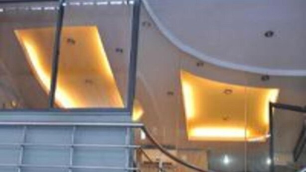 Un interior moderno con una escalera curva y paneles iluminados.