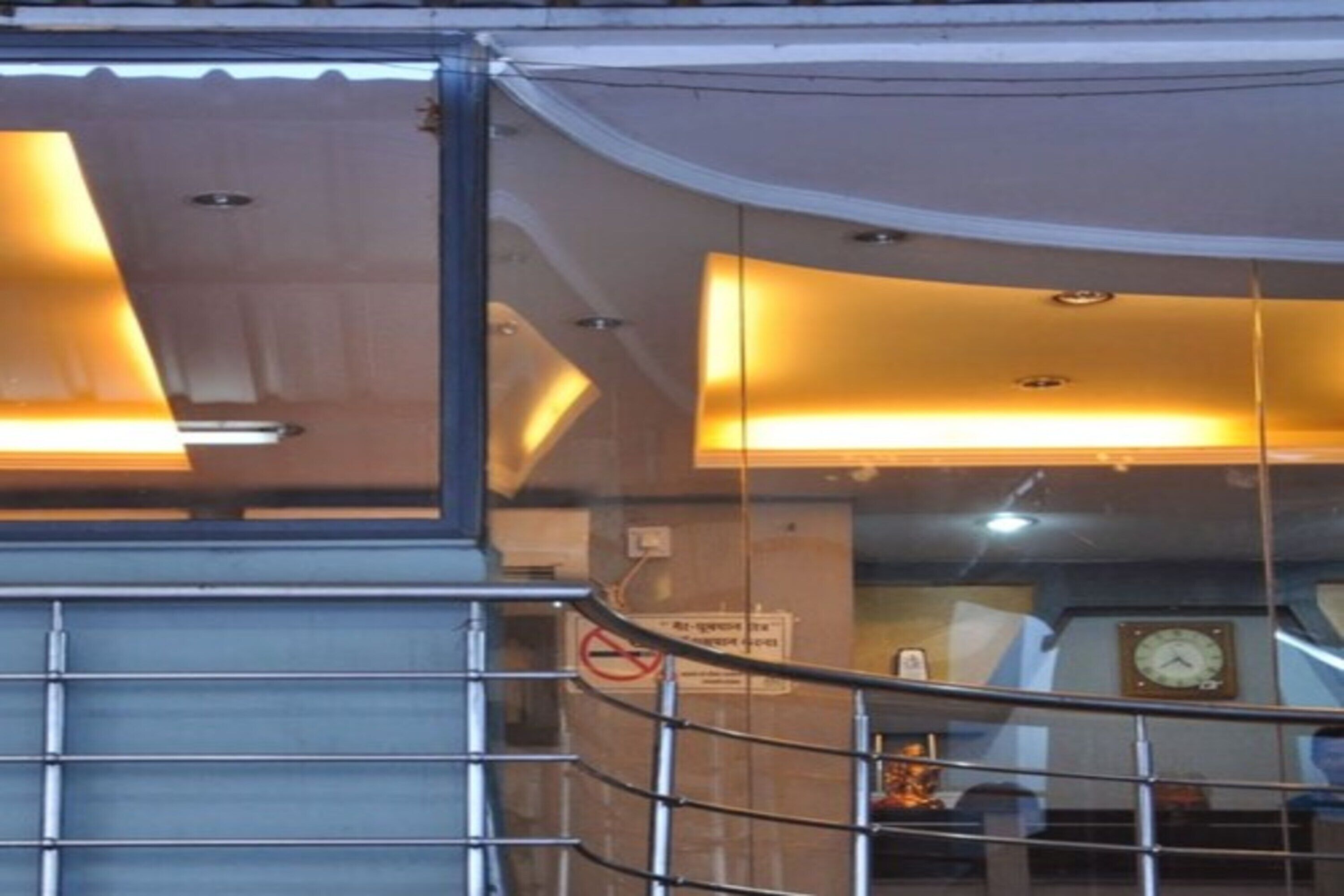 Et moderne interiør med buet loft, metalgelændere og et ur på væggen.