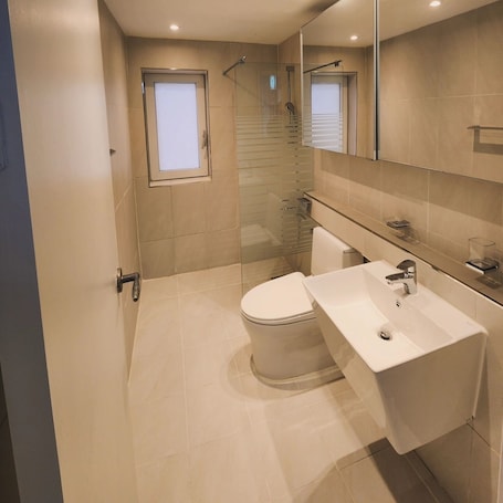A modern bathroom with a toilet, sink, and shower.. Hostel Fellaz