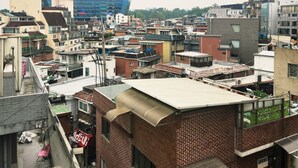 Una zona urbana densamente poblada con diversos edificios, incluyendo un destacado edificio de vidrio azul y varias estructuras de ladrillo.