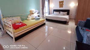 A hotel room with a bed, a smaller bed, a teddy bear, and a laptop on a table. - Homestay in Johor - Bear House (Johor Bahru)