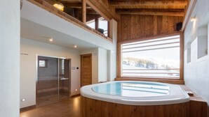 A modern indoor swimming pool with wooden walls and a view of a snowy landscape. - Lavarets Chambres d'Hotes (Ayas)