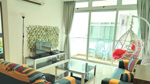 Uma sala de estar moderna com uma mesa de centro de vidro, sofás listrados, uma TV de tela plana e uma grande janela com vista para a cidade.