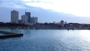 Vista para a orla marítima com edifícios ao fundo.