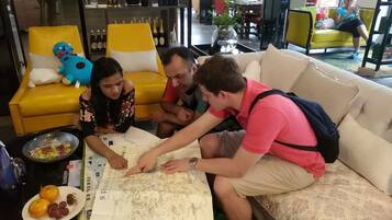 A group of people sitting on a sofa, examining a map.