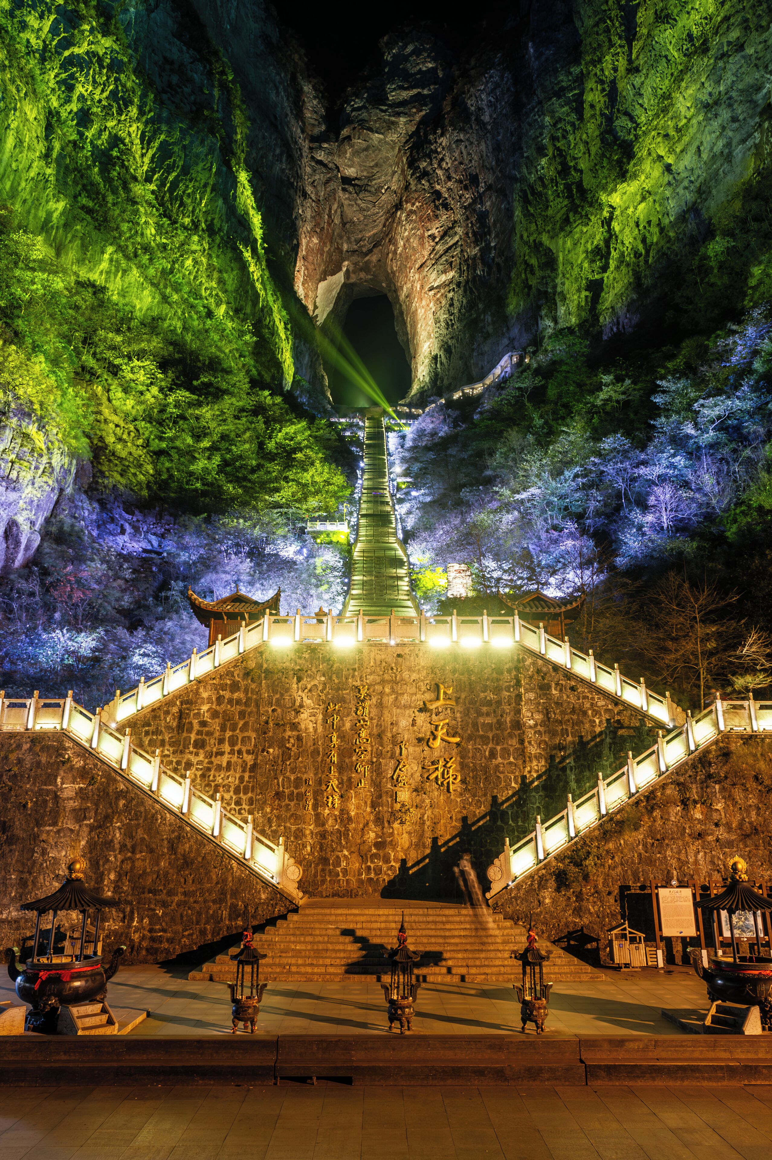 A stone staircase leading up to a traditional building with a lantern at the bottom.
