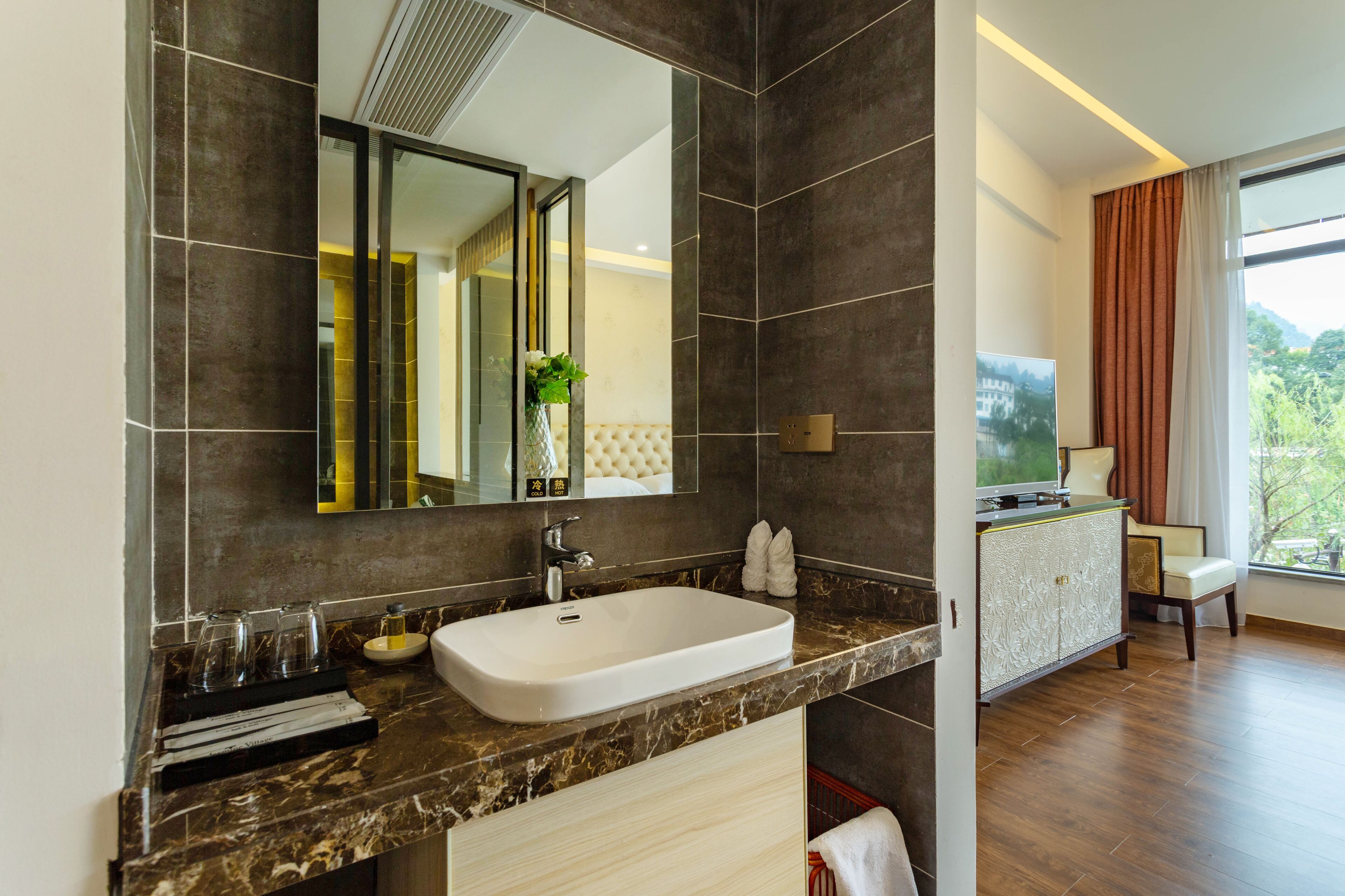 Une salle de bain moderne avec un grand miroir, un lavabo blanc et un meuble-lavabo avec un placard.