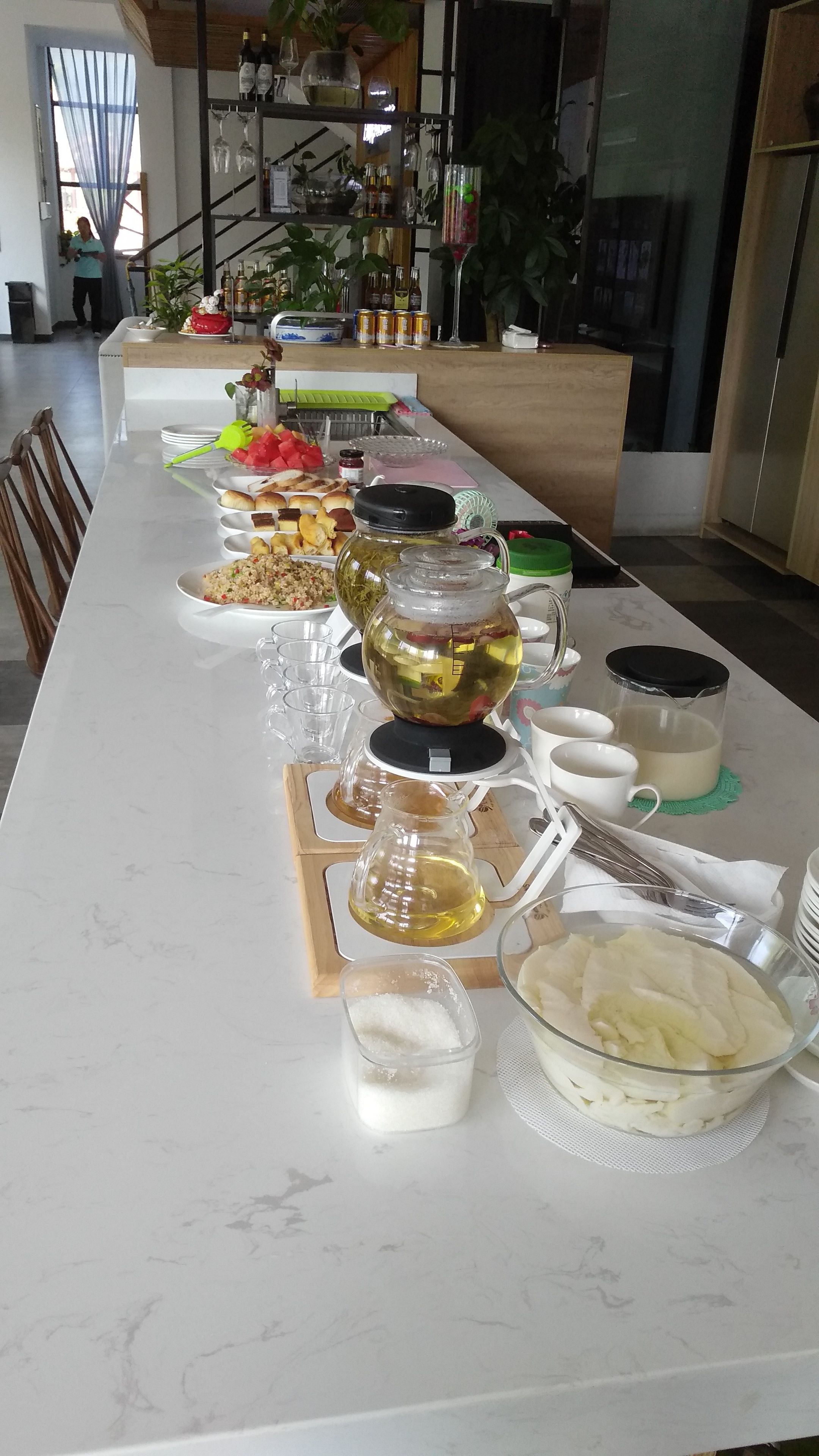Pitkä ruokapöytä, jonka päällä on erilaisia ruokia, juomia ja ruokailuvälineitä.