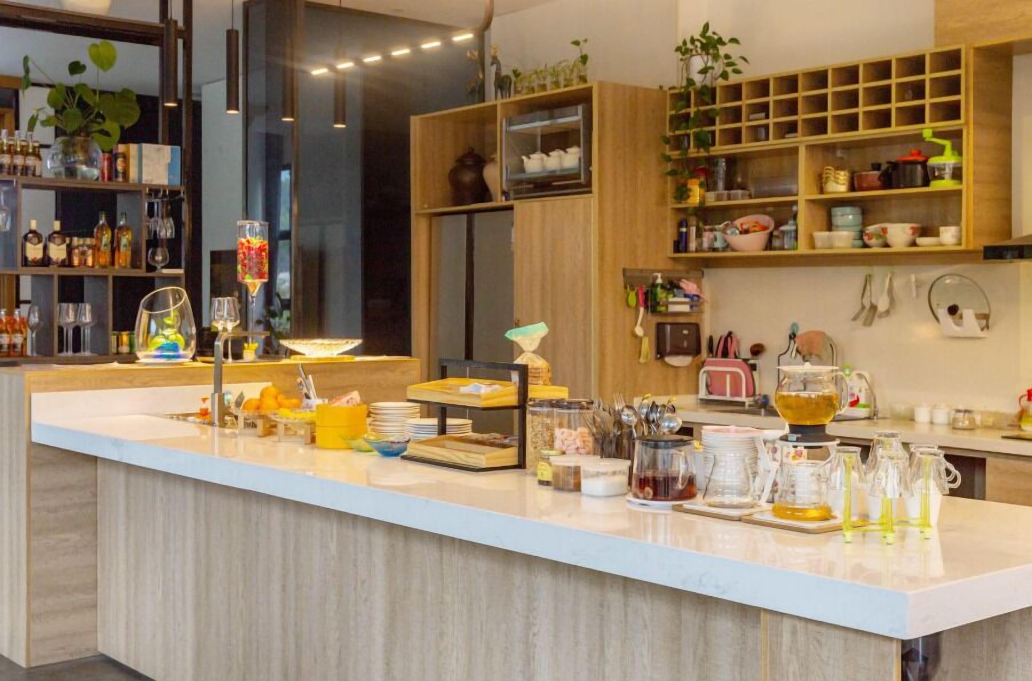 A modern kitchen with a central island, wooden cabinets, and various kitchen appliances.