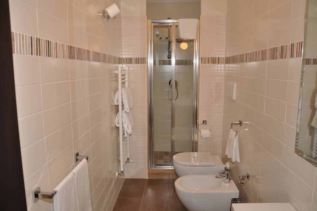 A modern bathroom with a glass-enclosed shower, a toilet, and a bidet.