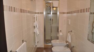 Ein modernes Badezimmer mit einer gläsernen Dusche, einer Toilette und einem Bidet.