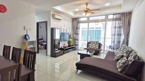 A modern living room with a dining area, a sofa set, and a TV. - Homestay in Johor - Secret Garden (Johor Bahru)