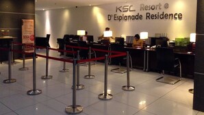 A reception area at KSL Resort with a sign for D'Esplanade Residence. There are reception desks, a red barrier, and a sign offering a 10% discount. - Homestay in Johor - Secret Garden (Johor Bahru)