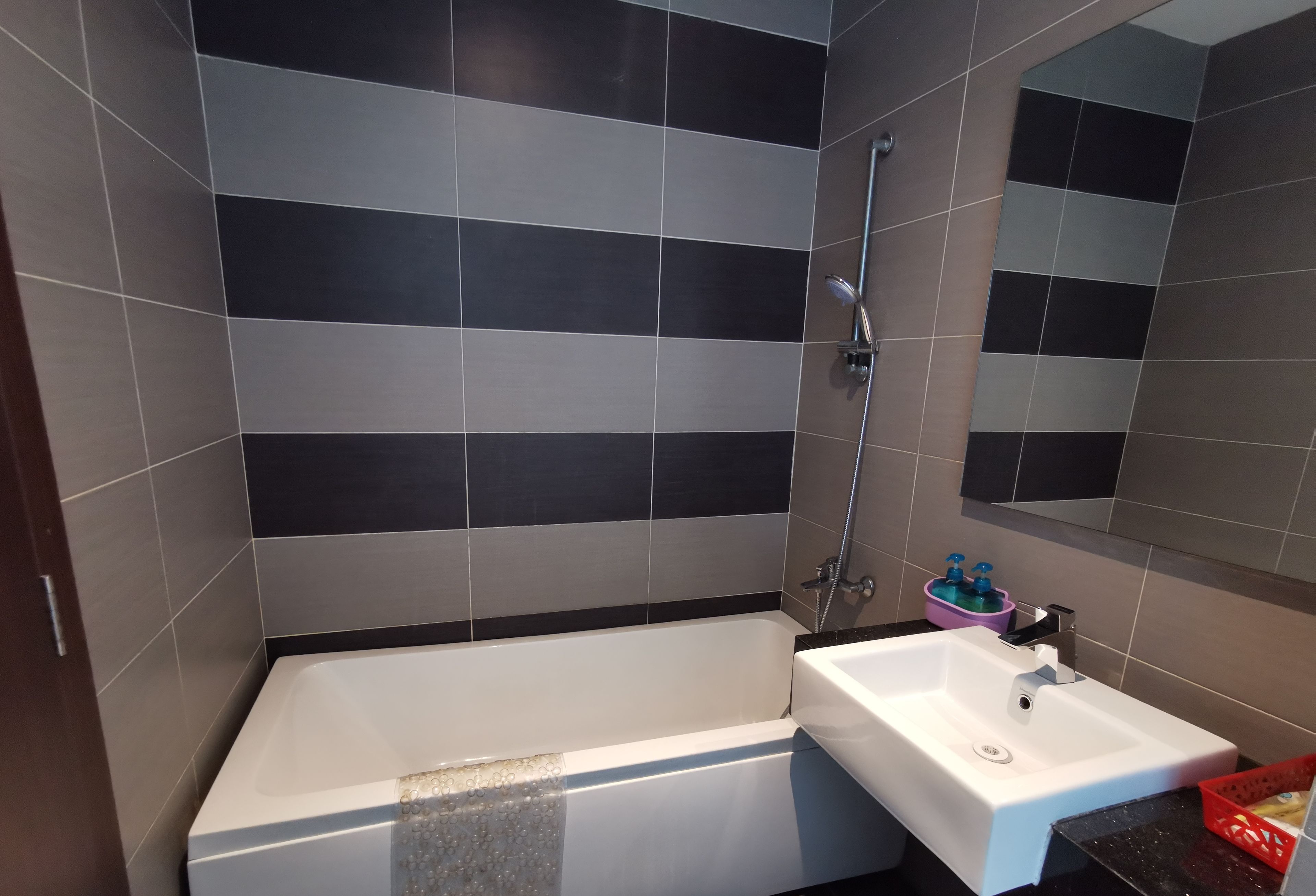 A modern bathroom with a bathtub, a sink, and a shower.