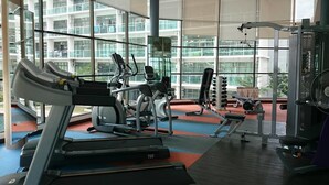 A gym with treadmills, elliptical machines, and weight equipment. - HomeStay in Johor - Palazio (Johor Bahru)