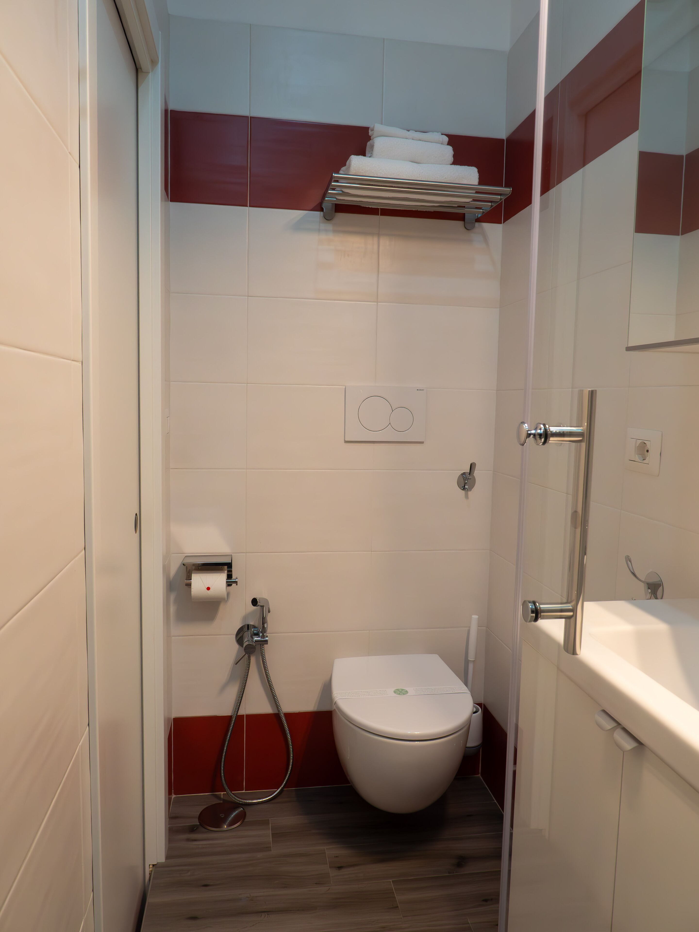 A compact bathroom with a toilet, a shower, and a sink.