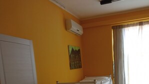 A room with bunk beds, a desk, a door, and an air conditioning unit on the wall. - Ostello Le Stanze del Sogno (Benevento)