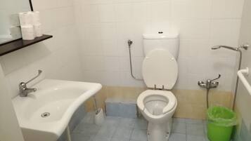 Een badkamer met toilet, wastafel en douche.
