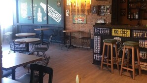 A restaurant interior with brick walls, hanging lights, and a bar area with stools. - Tum Hotel (Bandirma)