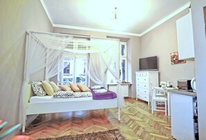 Une chambre à coucher comprenant un lit, un bureau, une chaise et un téléviseur.