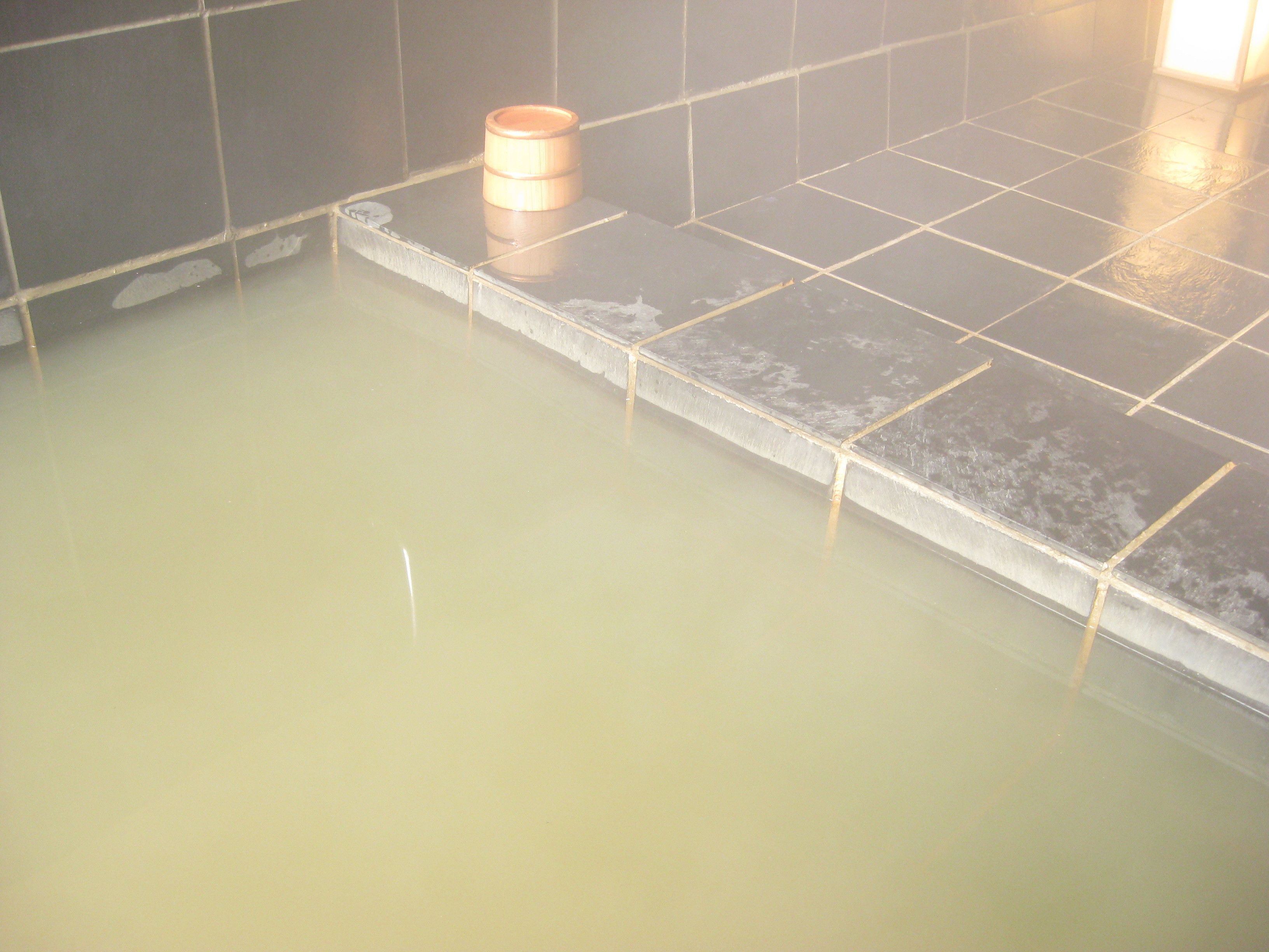 A tiled floor with a wooden barrel in a room.