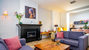 A modern living room with a fireplace, sofas, a coffee table, and a dining area. - Hotel Janssen (Valkenburg aan de Geul)