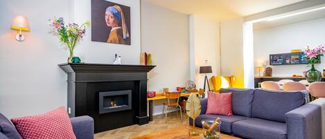 Una sala de estar moderna con chimenea, sofás, una mesa de centro y un comedor.