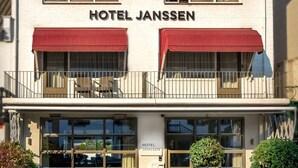A two-story building with the sign "HOTEL JANSEN" above the entrance. There are outdoor seating areas with tables and chairs, and potted plants are placed around the seating. - Hotel Janssen (Valkenburg aan de Geul)