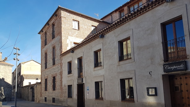 Un edificio con fachada de piedra, varias ventanas y un cartel que indica que es un hotel.