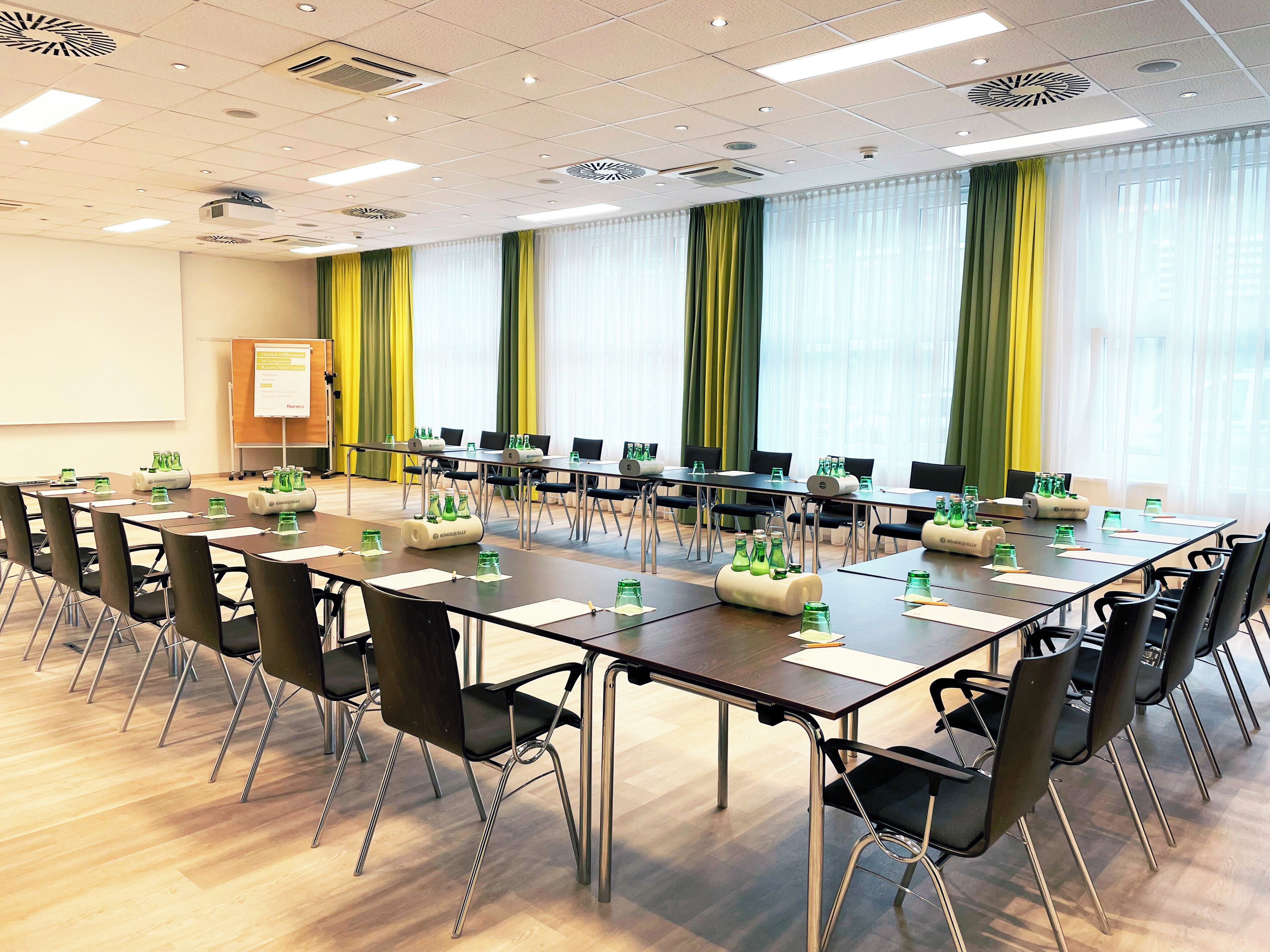 A conference room with a long table, chairs, and water bottles.