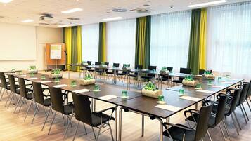 A conference room with a long table, chairs, and water bottles.
