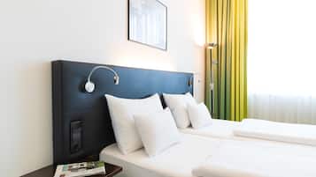 Een hotelkamer met een groot bed, twee nachtkastjes, een lamp en een lijst aan de muur.